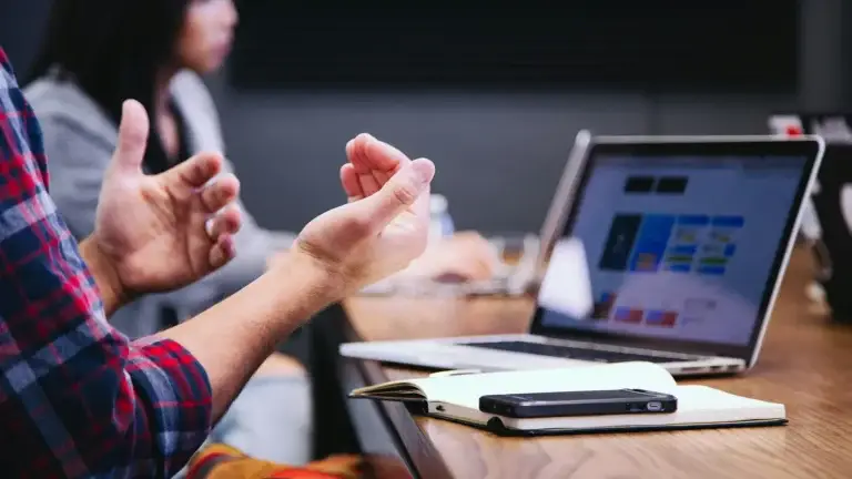 hands up near laptop on table